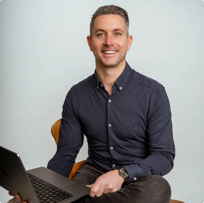 Dirk Megens, zittend op een stoel met zijn laptop op schoot